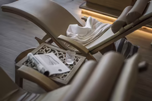 Bequeme Wellnessliege mit Handtuch, Getränk und Lektüre im gemütlichen Ruhebereich des Hotel Platzlhof.