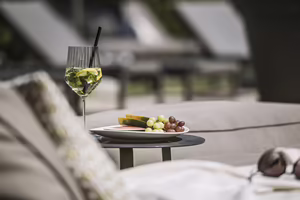 Erfrischender Drink und frisches Obst auf einer Ablage im Poolbereich des Hotel Platzlhof im Zillertal.
