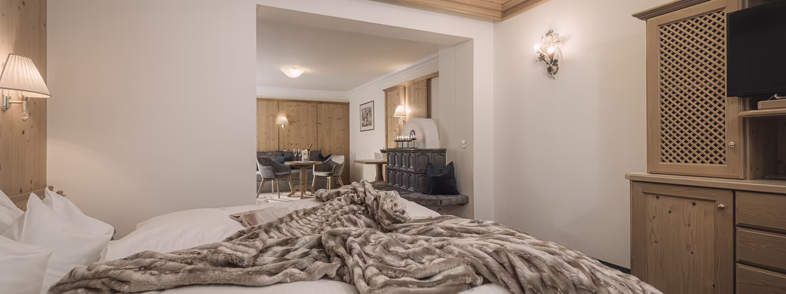 Blick vom Bett in die großzügige Feriensuite Zillertal mit Sitzecke, Essbereich und offenem Wohnkonzept.