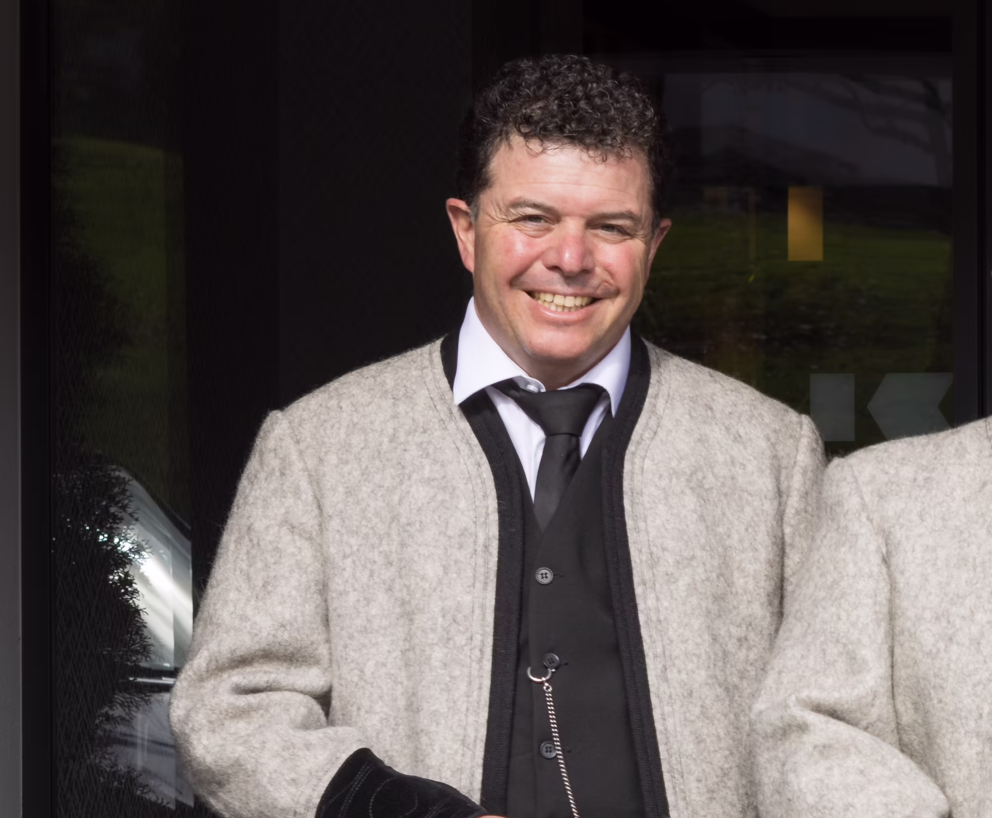 Geschwister Wimpissinger – Gastgeber im Platzlhof Andrea, Michael und Martin Wimpissinger in Tiroler Tracht vor dem Eingang des Hotel Platzlhof in Ried im Zillertal