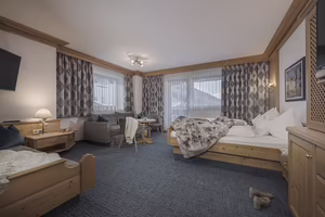 Helles, gemütliches Zimmer mit Holzmöbeln und Doppelbett.