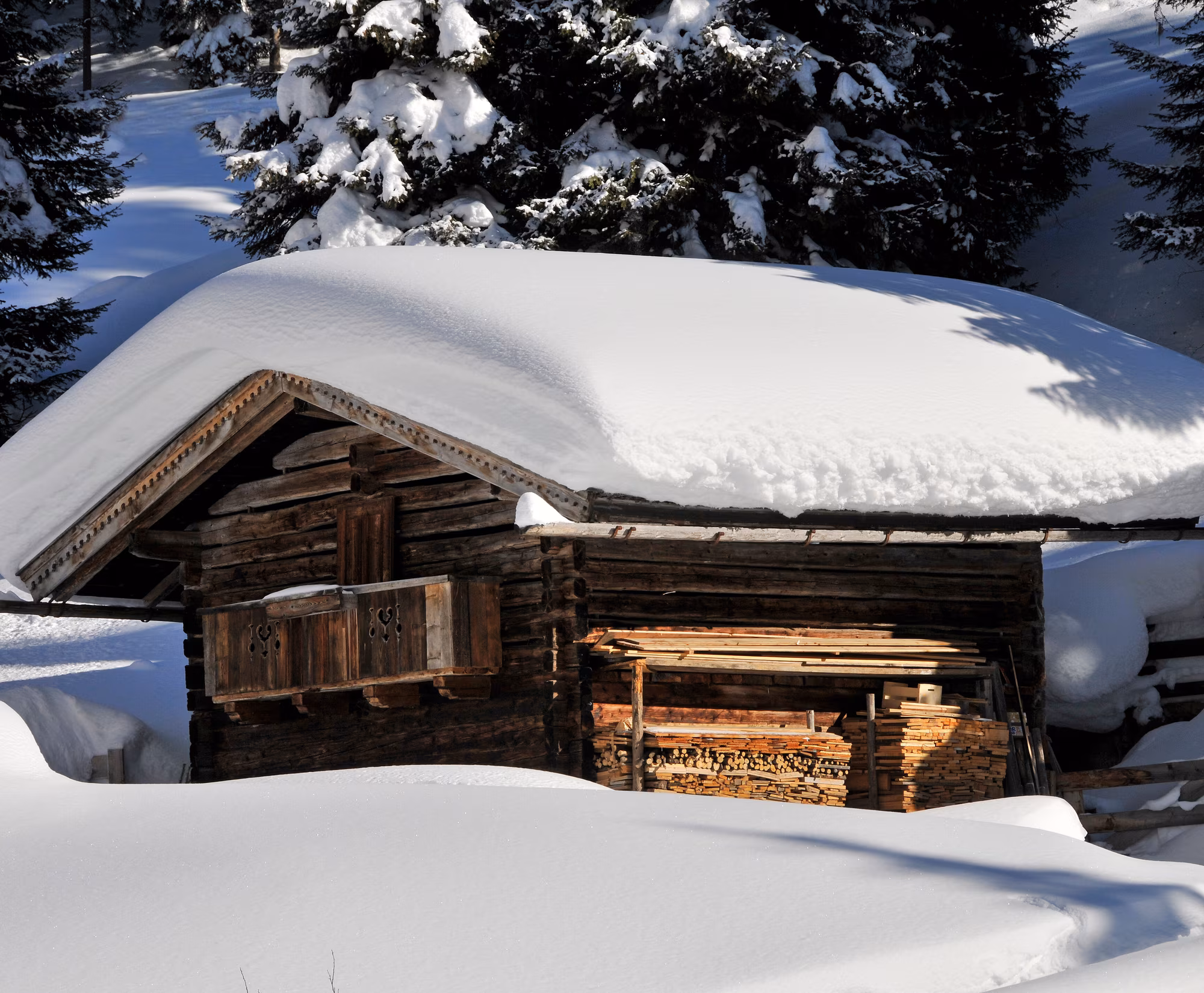 Hütte unter einer dicken Schneedecke im Winterwald.