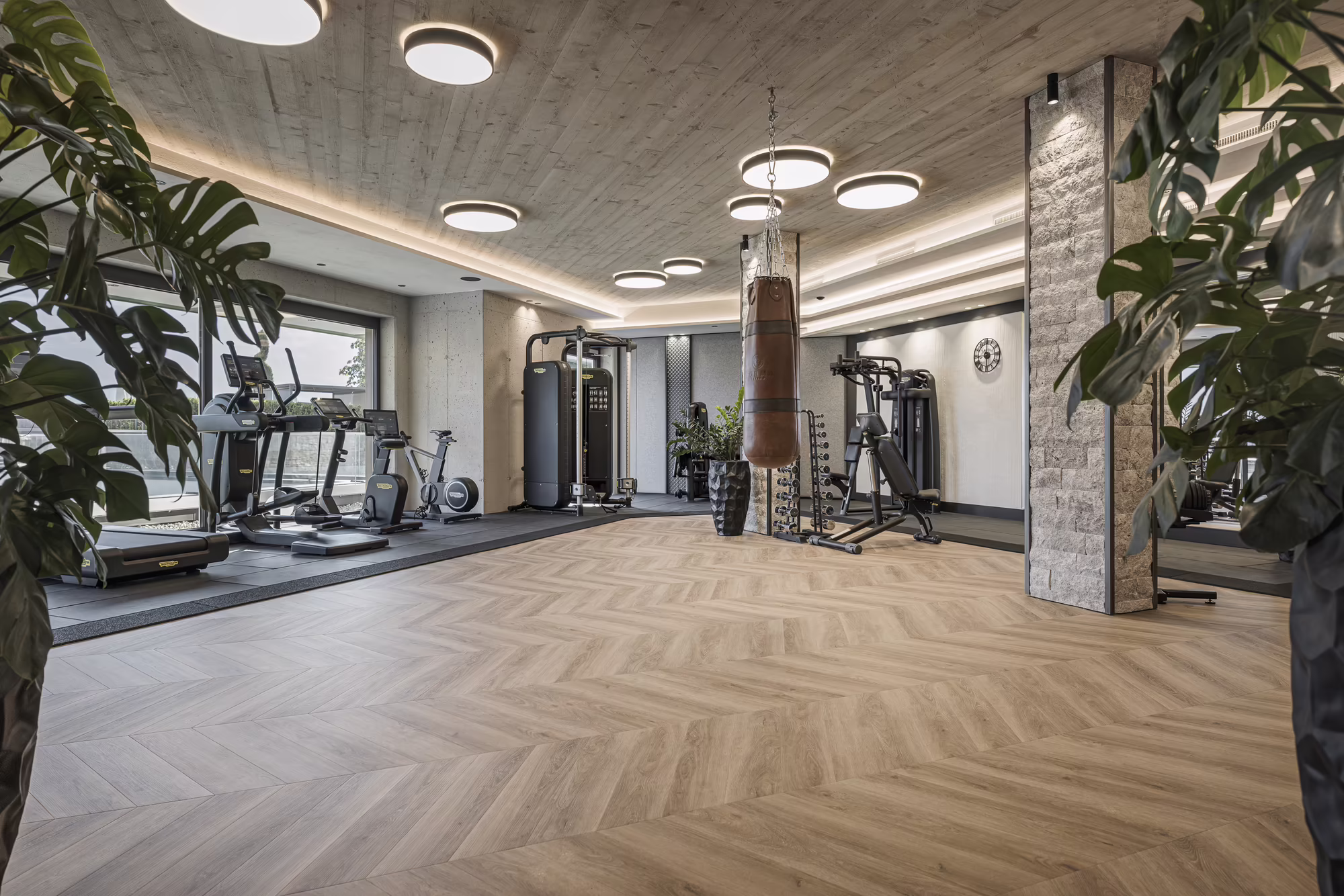 Moderner Fitnessraum im Hotel Platzlhof Moderner Fitnessraum im Hotel Platzlhof mit Ausdauergeräten, Kraftstationen und Boxsack für das Training im Urlaub.